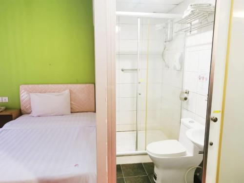 y baño con cama, ducha y aseo. en Homestay Kuching Hotel en Kuching