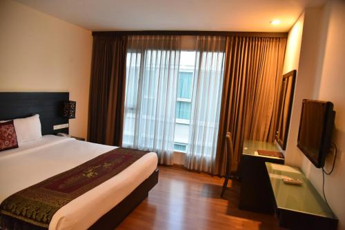 Säng eller sängar i ett rum på Boss Suites Nana Hotel