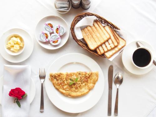a white table with a plate of omelet and toast at Heritage Gouri Haveli in Jodhpur