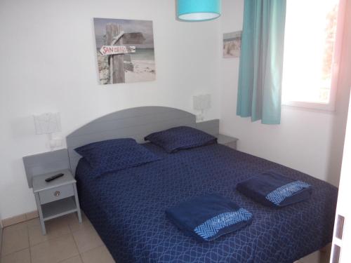 - une chambre avec un lit bleu et des oreillers bleus dans l'établissement T2 Turquoise Ondres plage avec piscine et tennis, à Ondres
