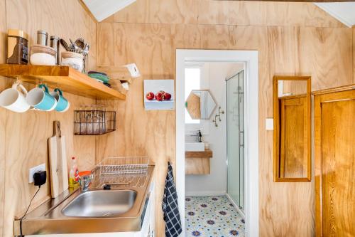 - une petite cuisine avec un évier et un miroir dans l'établissement Ahuriri Studio Cottage, à Napier