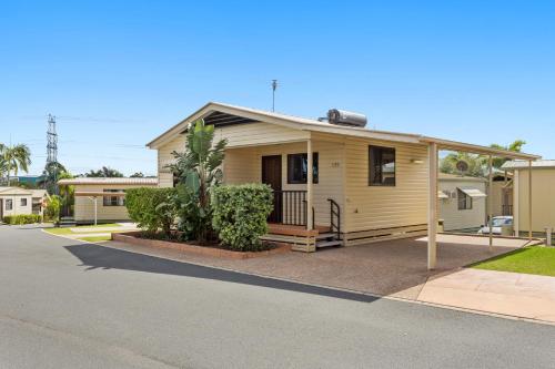 a small yellow house on the side of a street at Brisbane Holiday Village in Brisbane