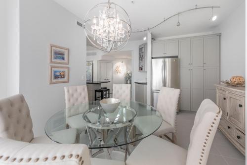 a dining room with a glass table and white chairs at Kelowna Discovery in Kelowna