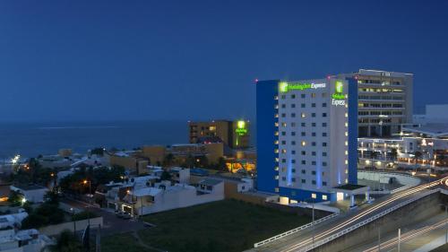 a city skyline at night with a tall building at Holiday Inn Express Veracruz Boca del Rio by IHG in Veracruz