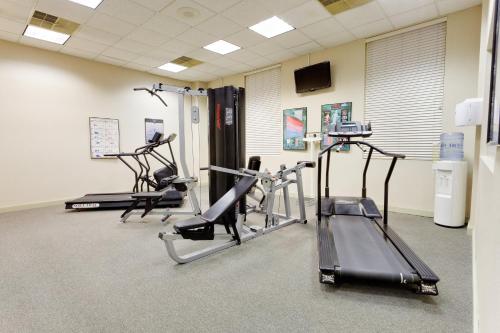 a gym with three tread machines in a room at Burrstone Inn, an Ascend Collection Hotel in Utica