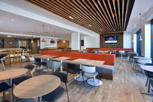 a restaurant with tables and chairs in it at Holiday Inn Express - Rouen Centre - Rive Gauche, an IHG Hotel in Rouen