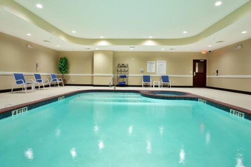 a pool in a hotel room with blue chairs at Holiday Inn Express - Eunice by IHG in Eunice