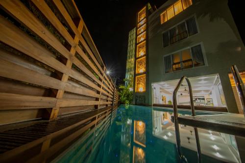 a swimming pool in front of a building at night at de MODA Boutique Hotel Galle in Galle