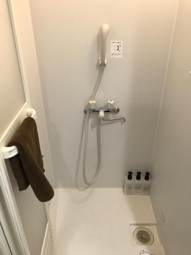 a shower stall in a bathroom with a sink at Syukur Ofuna in Kamakura