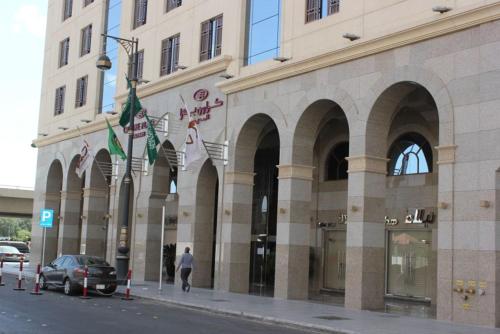 a building with a car parked in front of it at Crowne Plaza Madinah by IHG in Al Madinah