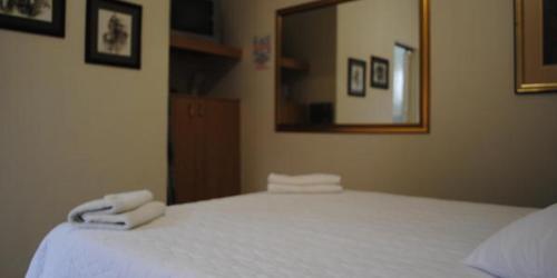 Un dormitorio con una cama blanca con toallas. en Garden View Lodge, en Mahikeng
