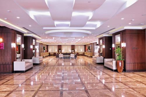 a lobby with chairs and tables in a building at Crowne Plaza Madinah, an IHG Hotel in Al Madinah