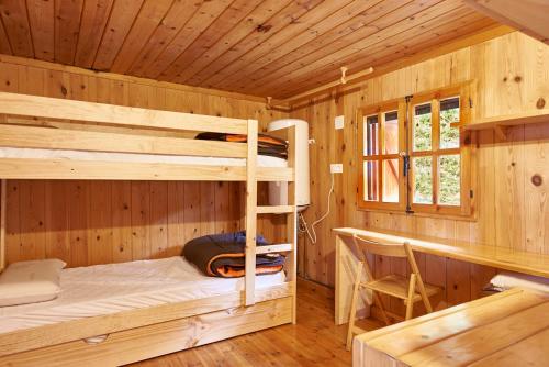グエハル・シエラにあるCabaña Las Víborasの木造キャビン内の二段ベッド付きのベッドルーム1室を利用します。