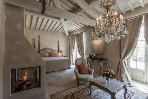 a living room with a chandelier and a fireplace at Borgo Santo Pietro in Chiusdino