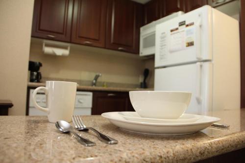 a kitchen counter with a plate and a bowl and spoon at Staybridge Suites London by IHG in London