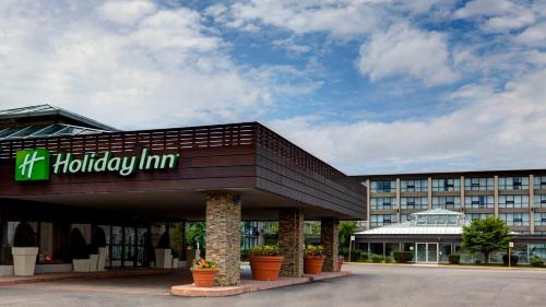 a hotel with a hilton inn sign in front of a building at Holiday Inn Toronto Airport East by IHG in Toronto