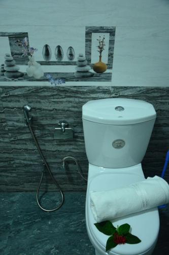 a bathroom with a toilet with a towel on it at Seven Luck Palace in Kandy