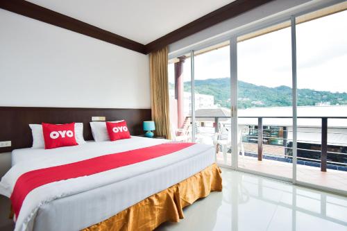 a bedroom with a large bed and a large window at OYO 389 Sira Boutique Residence in Patong Beach