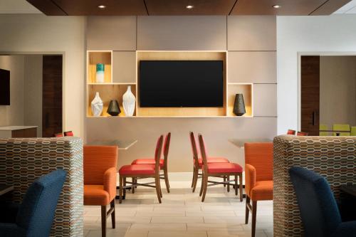 a waiting room with chairs and a flat screen tv at Holiday Inn Express Williamsburg by IHG in Williamsburg