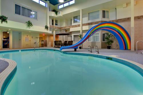 einen Pool mit einer Regenbogen-Rutsche in einem Hotel in der Unterkunft Holiday Inn Express Red Deer, an IHG Hotel in Red Deer