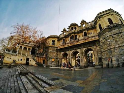 un edificio viejo con gente parada fuera de él en Mohan Villa Guest House, en Udaipur