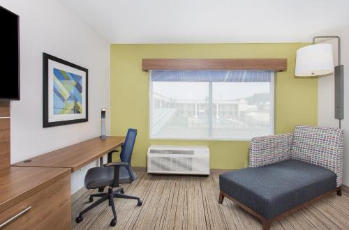a room with a desk and a chair and a window at Holiday Inn Express Williamsburg by IHG in Williamsburg