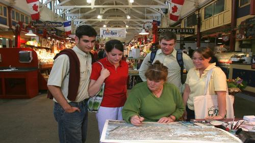 a group of people looking at a map in a store at Holiday Inn Express Hotel & Suites Saint John Harbour Side by IHG in Saint John