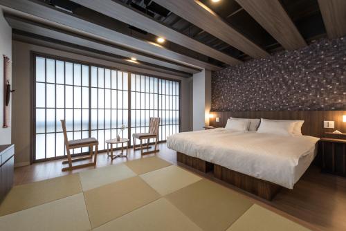 1 dormitorio con 1 cama grande, mesa y sillas en 谷町君・ホテルひとめぼれ 京都四条烏丸, en Kioto