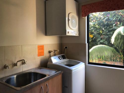 a small kitchen with a sink and a washing machine at Alfred Cove Short Stay in Perth