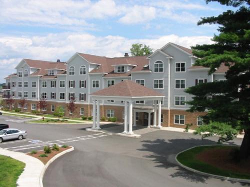 a large white building with a parking lot at Holiday Inn Express Hotel & Suites White River Junction by IHG in White River Junction