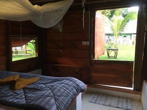 a bedroom with a bed and a large window at Lazy Bones in Koh Rong Sanloem