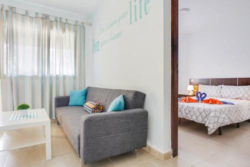 un soggiorno con divano e letto di 8211 Bungalow Costa Calma Wifi a Costa Calma