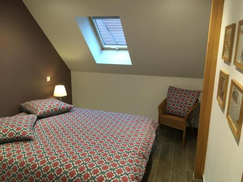 ein kleines Schlafzimmer mit einem Bett und einem Dachfenster in der Unterkunft Les 3 Alsaciennes in Sigolsheim