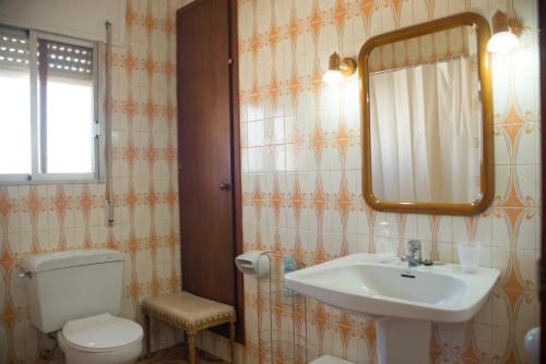 ein Badezimmer mit einem Waschbecken, einem WC und einem Spiegel in der Unterkunft villa berta in Vinarós