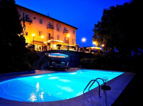 een zwembad voor een gebouw 's nachts bij Ristorante Albergo Ca' Vittoria in Tigliole