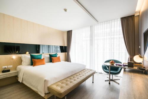 a hotel room with a large bed and a desk at Hotel Vista in Pattaya Central
