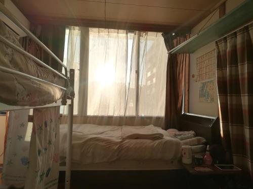 sypialnia z łóżkiem piętrowym i oknem w obiekcie Credo Sasebo w mieście Sasebo