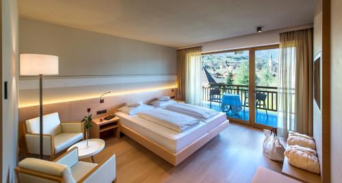 a hotel room with a bed and a balcony at Hotel Spitaler in Appiano sulla Strada del Vino