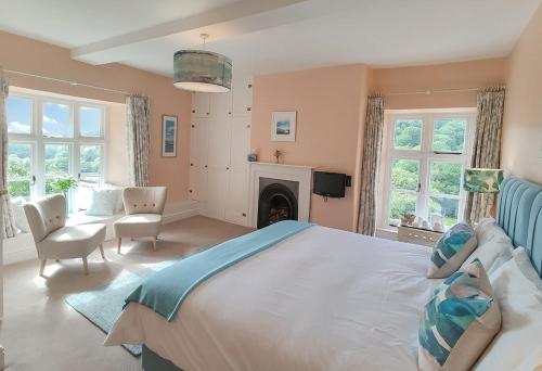 een grote slaapkamer met een groot bed en een open haard bij Eastwrey Barton Country House in Lustleigh