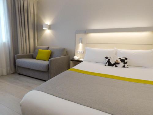 a hotel room with a bed and a chair at Holiday Inn Express Pamplona by IHG in Mutilva Baja