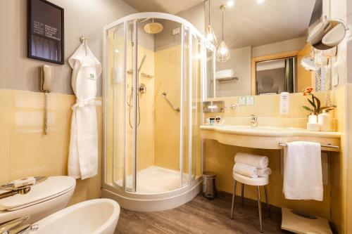 a bathroom with a shower and a toilet and a sink at Holiday Inn Milan Garibaldi Station by IHG in Milan