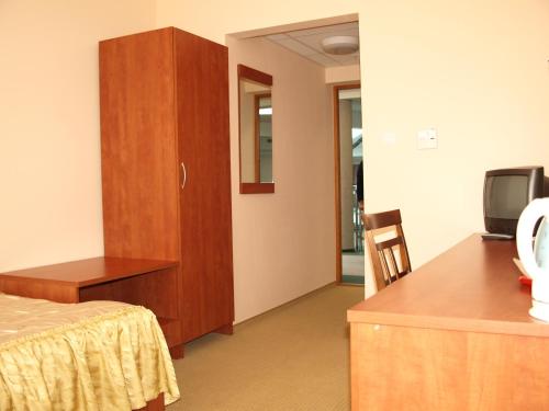 a room with a bed and a cabinet and a tv at Pokoje Gościnne WSAP in Ostrołęka