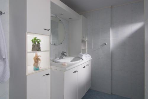 a white bathroom with a sink and a shower at Casa Di Giovani in Kokkini Khanion