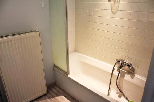 een badkamer met een bad en een douche bij Thalassa 15 in Zeebrugge
