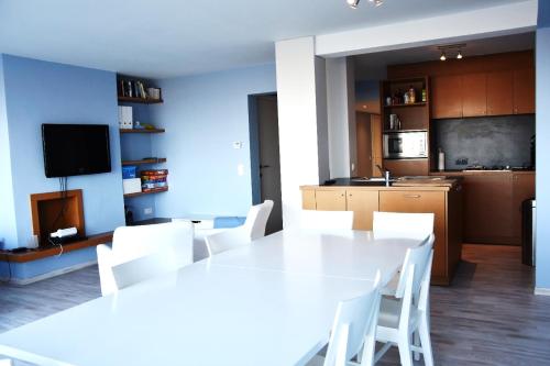 een keuken met een witte tafel en witte stoelen bij Thalassa 15 in Zeebrugge