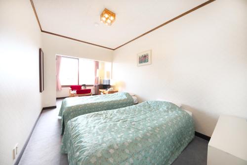 A bed or beds in a room at Shiga Swiss Inn
