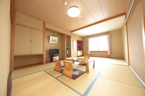 a large living room with a table and chairs at Shiga Swiss Inn in Yamanouchi