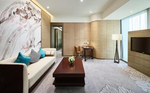 a living room with a couch and a tv at Crowne Plaza Nanning City Center by IHG in Nanning