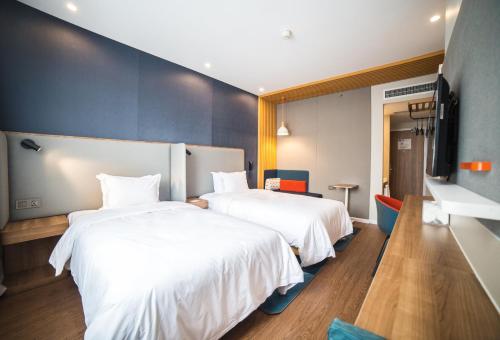 two beds in a hotel room with white sheets at Holiday Inn Express Nanjing Xuanwu Lake by IHG in Nanjing