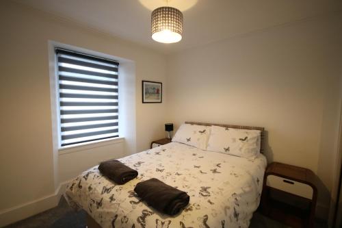 a bedroom with a bed with two pillows on it at Serviced Accommodation Moray Lossiemouth in Lossiemouth